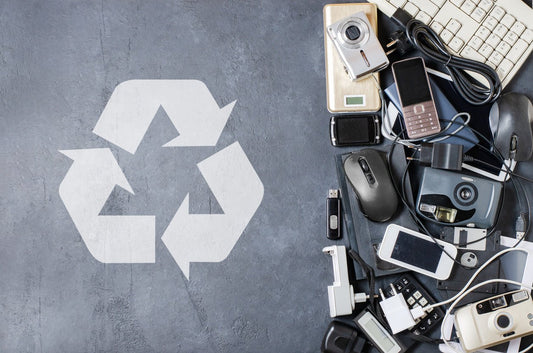 recycle graphic next to a pile of old technology
