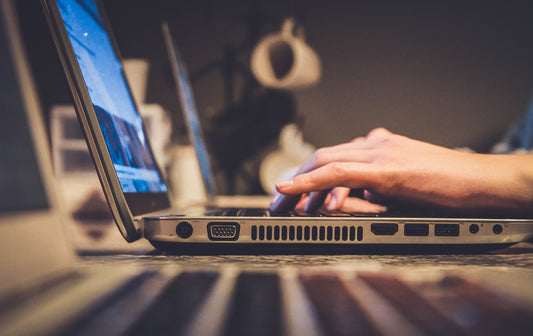 person typing on a laptop whilst sat at a desk