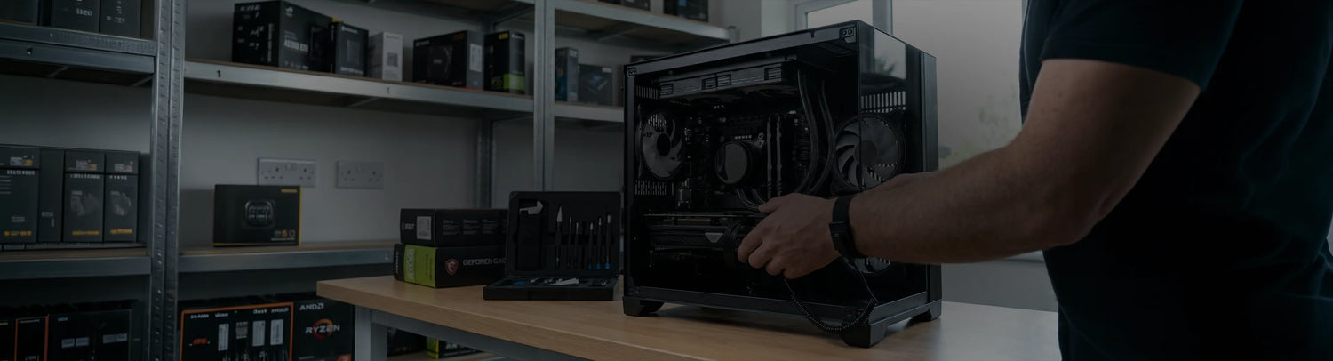 A computer building specialist assembling GTR PC from gotraka in a computer electronics shop, which has PC components like processor, graphics card, storage devicess etc on a rack and table