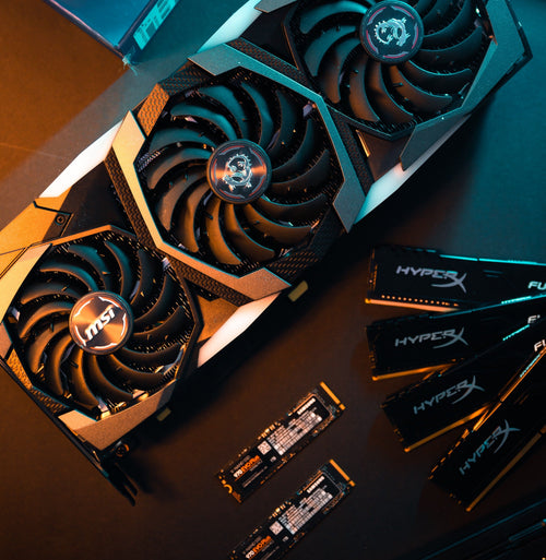 Three black computer graphics cards with fans, on a dark background